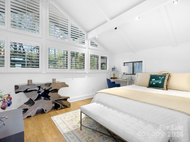 bedroom featuring beam ceiling, high vaulted ceiling, and light hardwood / wood-style flooring