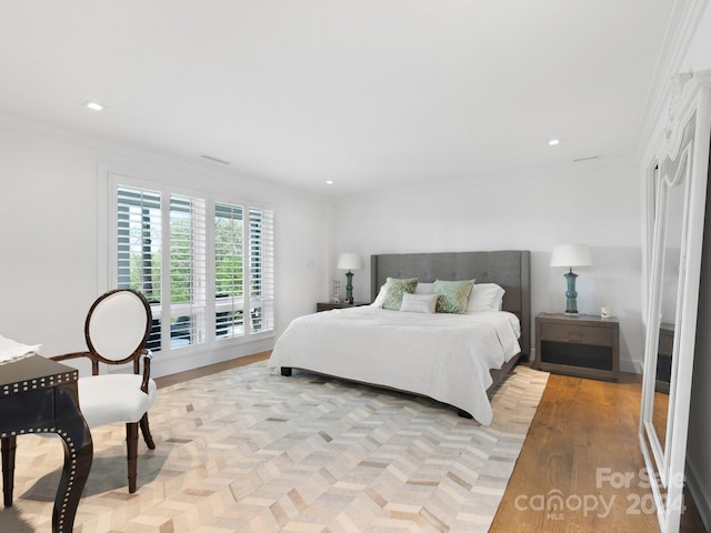 bedroom featuring crown molding and light hardwood / wood-style flooring