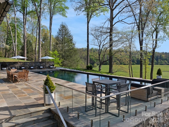 view of swimming pool featuring a patio, a water view, and an outdoor hangout area