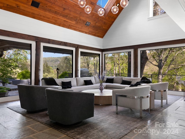 living room with a wealth of natural light, high vaulted ceiling, and wood ceiling