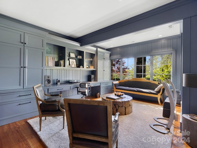 living room with crown molding, built in desk, and hardwood / wood-style flooring