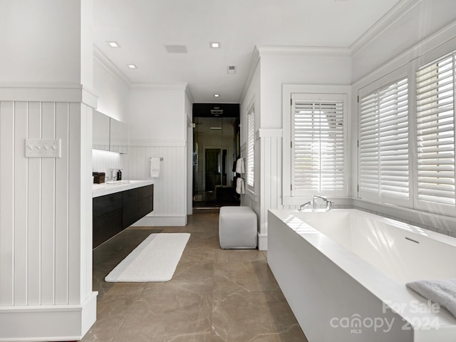 full bathroom with vanity, a garden tub, crown molding, and a wainscoted wall