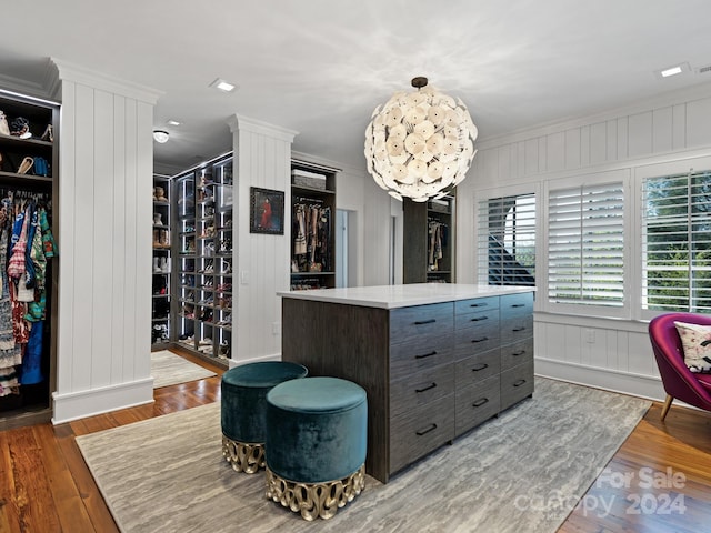 spacious closet with a chandelier and hardwood / wood-style floors