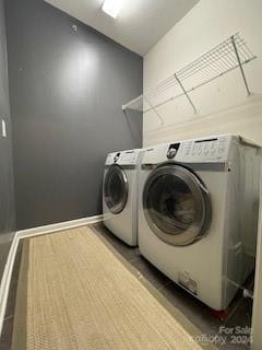 clothes washing area featuring washer and dryer and hardwood / wood-style flooring