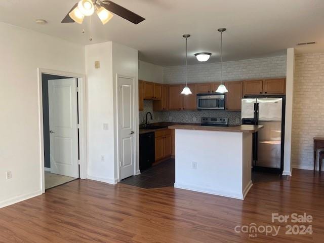 kitchen featuring a center island, tasteful backsplash, dark hardwood / wood-style flooring, decorative light fixtures, and appliances with stainless steel finishes