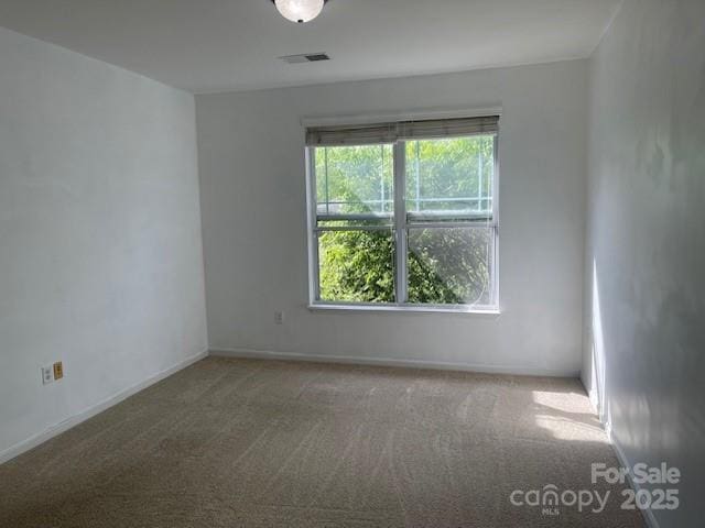 carpeted empty room with baseboards and visible vents