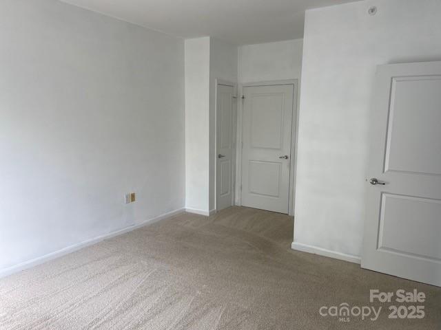 unfurnished bedroom featuring baseboards and carpet
