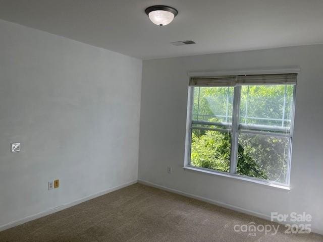 carpeted empty room with baseboards and visible vents