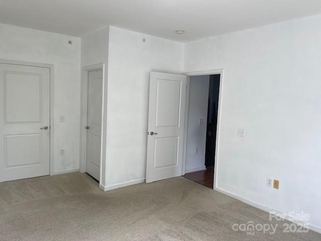 unfurnished bedroom featuring baseboards and carpet