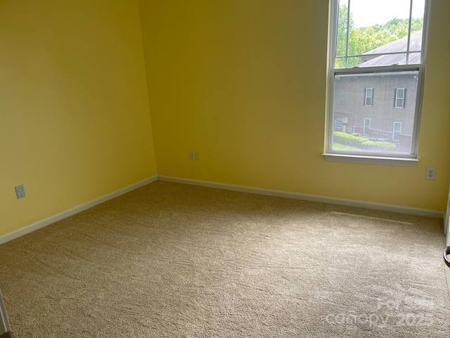 empty room featuring baseboards and carpet flooring