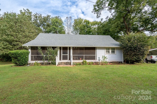 ranch-style house with a front yard and a sunroom