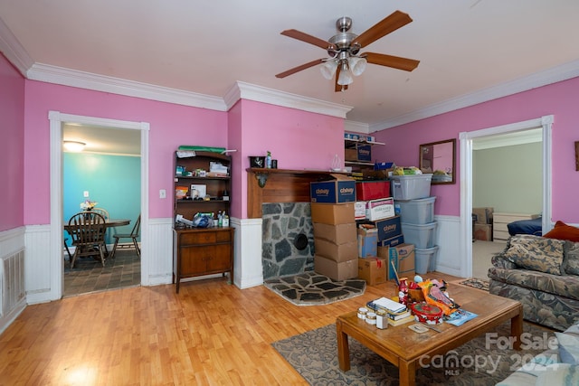 living room with light wood-type flooring, ceiling fan, and crown molding