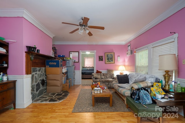 living room with ceiling fan, crown molding, and light wood-type flooring