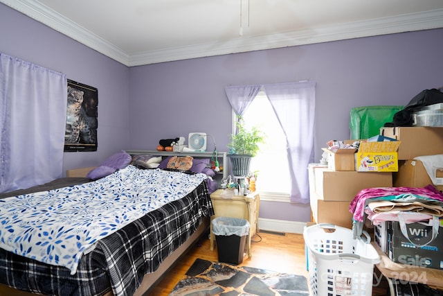 bedroom with hardwood / wood-style flooring and crown molding