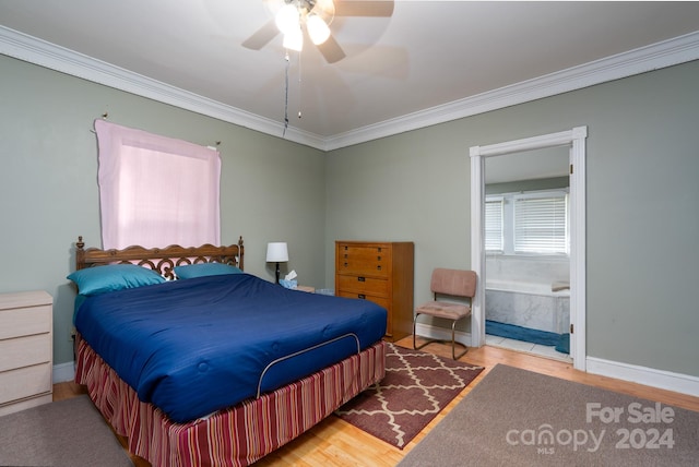 bedroom featuring ceiling fan, wood-type flooring, ornamental molding, and ensuite bath