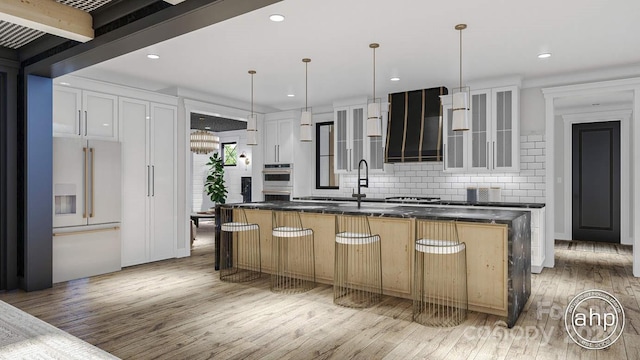 kitchen featuring decorative light fixtures, high end fridge, white cabinetry, and a center island