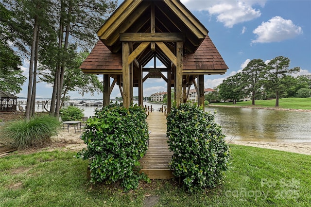 dock area featuring a water view and a lawn