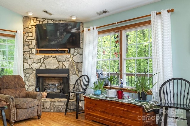 sitting room with a fireplace, hardwood / wood-style floors, and a textured ceiling