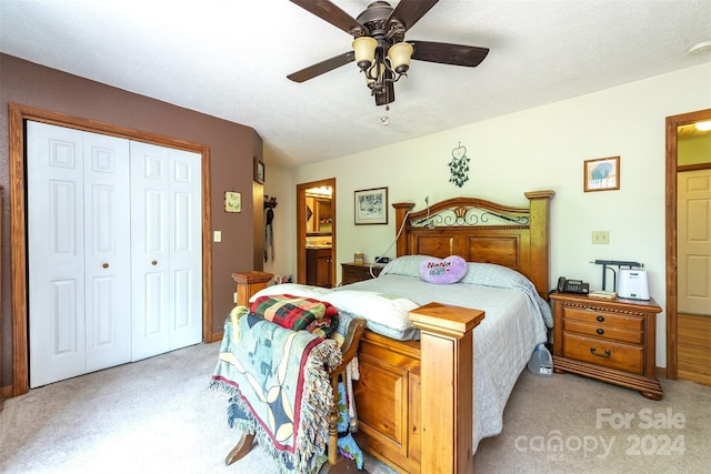 bedroom featuring a closet, ceiling fan, ensuite bathroom, and carpet flooring