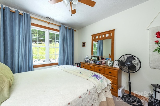 bedroom featuring ceiling fan and a textured ceiling