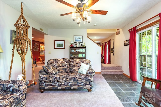 tiled living room with ceiling fan and a textured ceiling