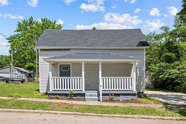 bungalow-style house featuring covered porch and a front yard