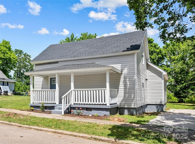 view of front of house with covered porch and a front lawn