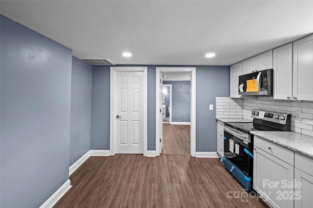 kitchen with tasteful backsplash, white cabinetry, dark hardwood / wood-style floors, and stainless steel electric range