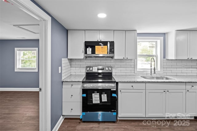 kitchen featuring decorative backsplash, appliances with stainless steel finishes, sink, dark hardwood / wood-style floors, and white cabinetry