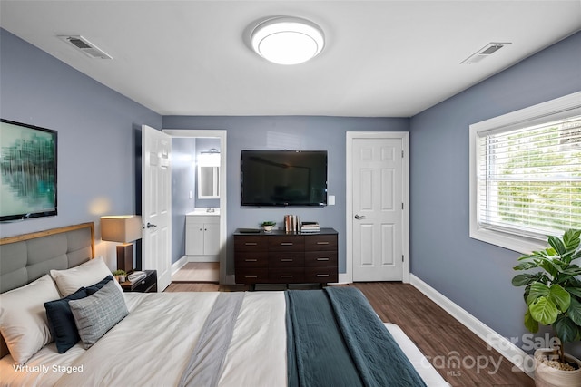 bedroom featuring hardwood / wood-style flooring and connected bathroom