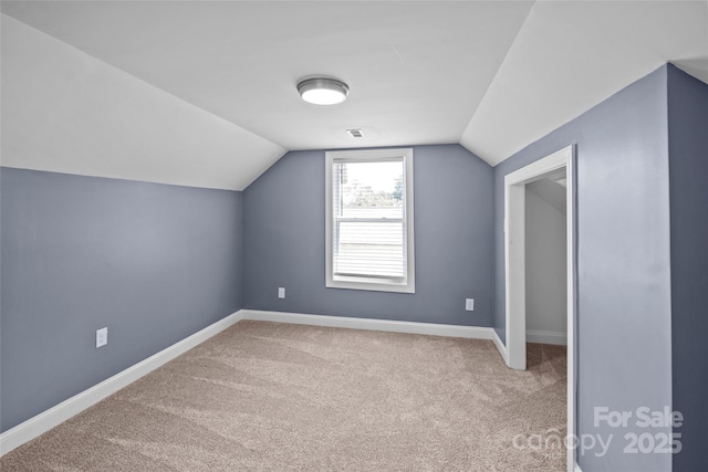 bonus room featuring light carpet and vaulted ceiling