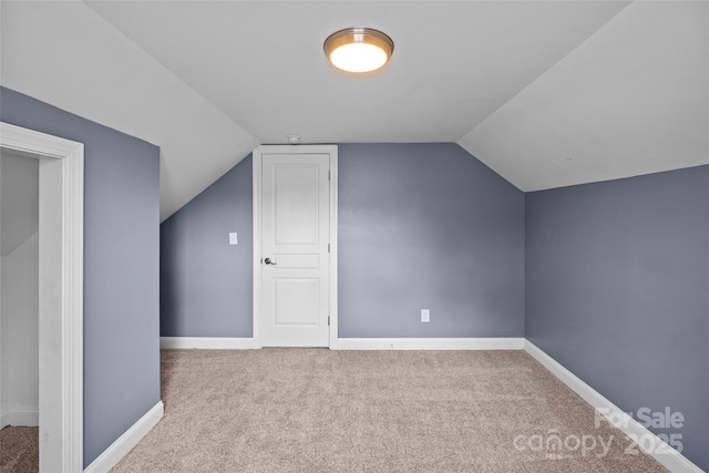 bonus room with light carpet and vaulted ceiling