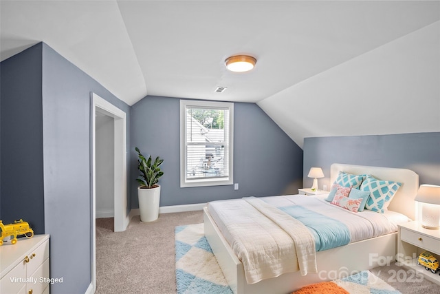 carpeted bedroom with lofted ceiling