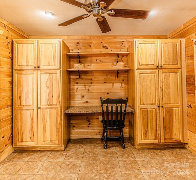 kitchen featuring wood walls and ceiling fan