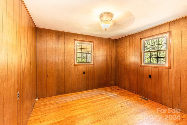 empty room featuring wood walls and light wood-type flooring