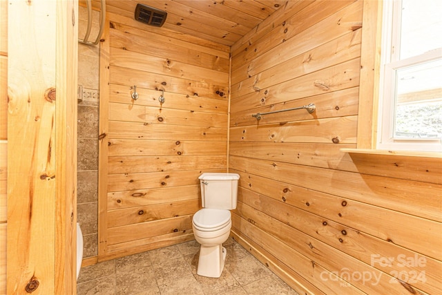 bathroom with wood ceiling, toilet, and wooden walls