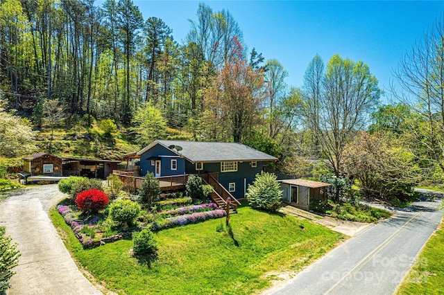 view of front of house featuring a wooden deck and a front yard