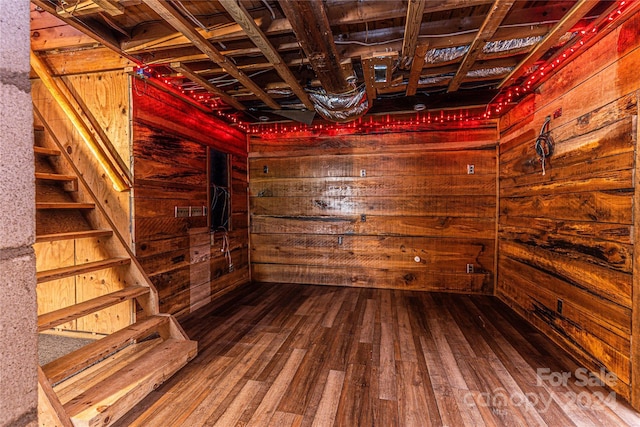 basement featuring hardwood / wood-style floors and wood walls