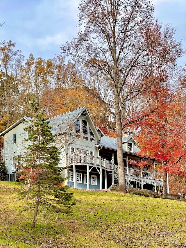 back of property featuring a yard and a wooden deck