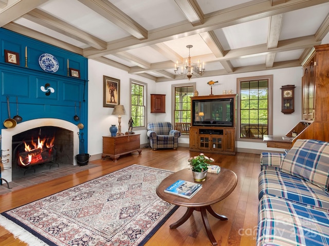 living room with beamed ceiling, coffered ceiling, a notable chandelier, and dark hardwood / wood-style flooring