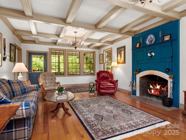 living room with coffered ceiling, hardwood / wood-style flooring, a notable chandelier, and beam ceiling