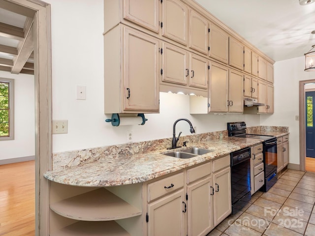 kitchen featuring light stone countertops, cream cabinets, black appliances, beamed ceiling, and sink