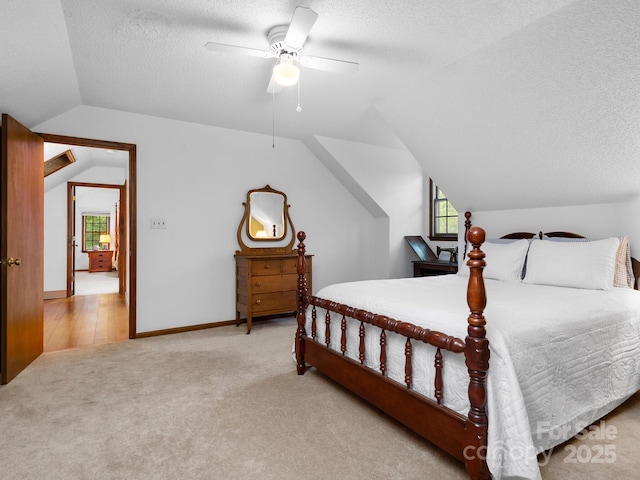 carpeted bedroom featuring lofted ceiling, multiple windows, a textured ceiling, and ceiling fan