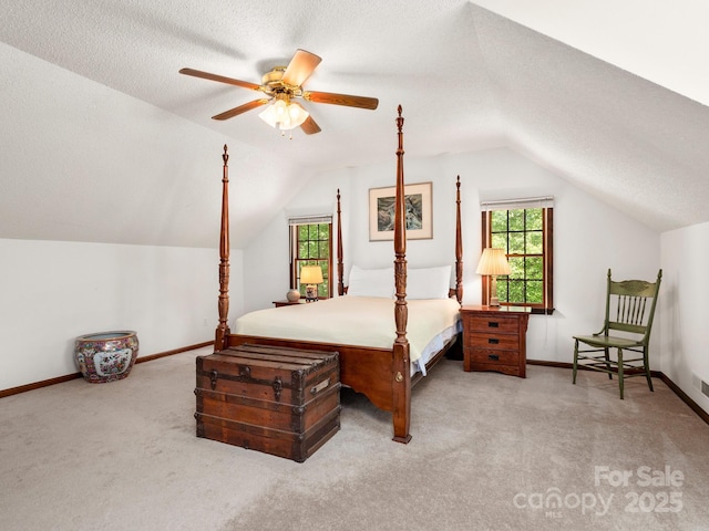 carpeted bedroom featuring vaulted ceiling, a textured ceiling, and ceiling fan