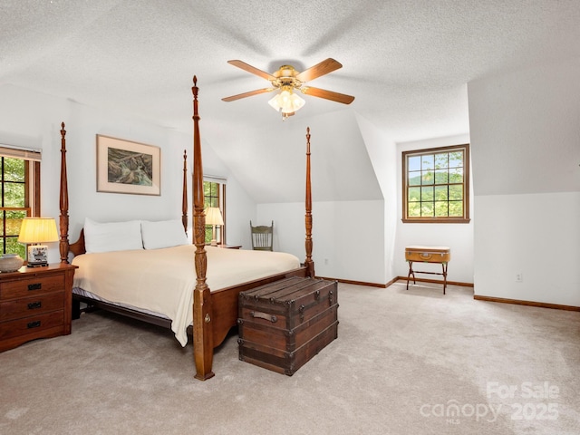 bedroom featuring lofted ceiling, light colored carpet, ceiling fan, and a textured ceiling