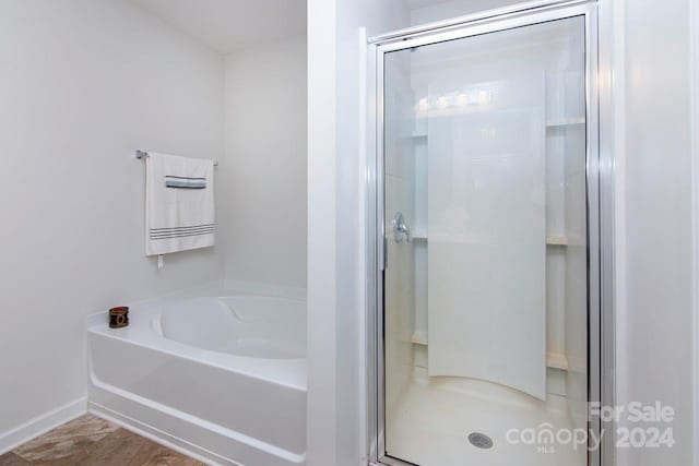 bathroom featuring independent shower and bath