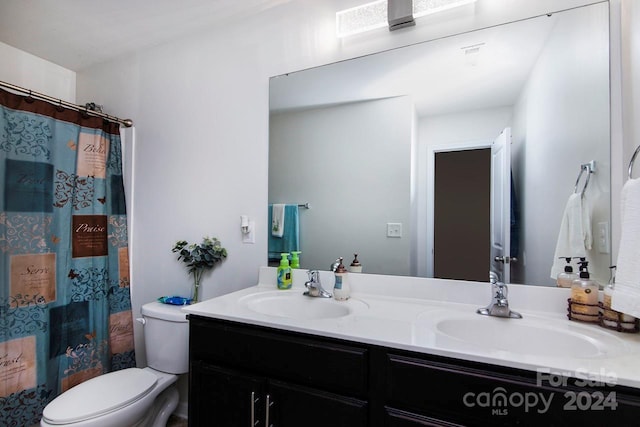 bathroom featuring toilet, vanity, and a shower with shower curtain