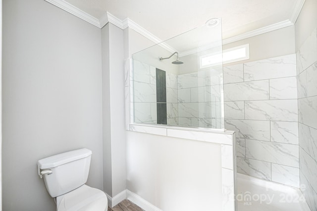 bathroom with tiled shower, crown molding, wood-type flooring, and toilet