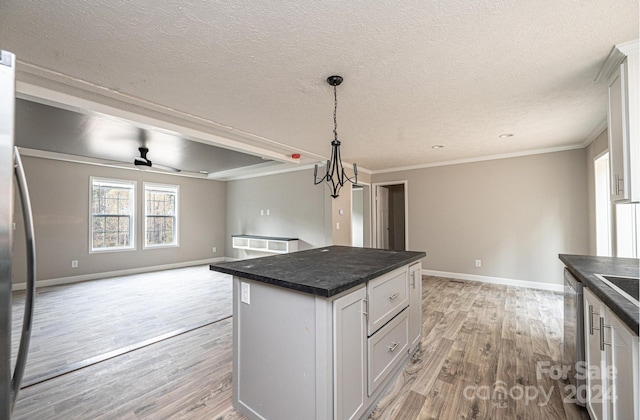 kitchen with white cabinetry, light hardwood / wood-style floors, crown molding, and a kitchen island