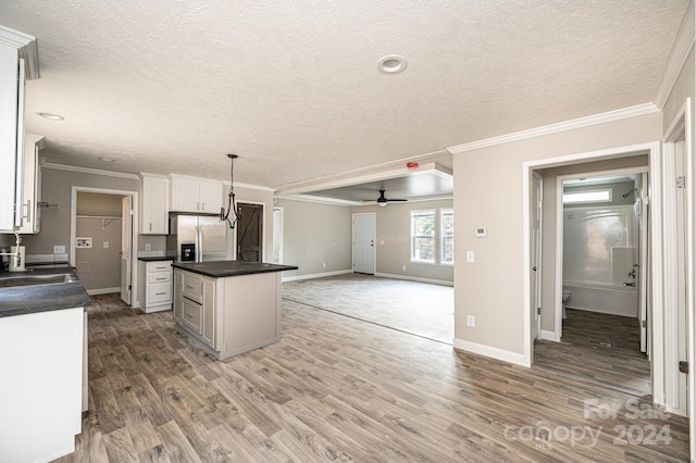 kitchen with a center island, white cabinetry, ceiling fan, pendant lighting, and stainless steel fridge with ice dispenser